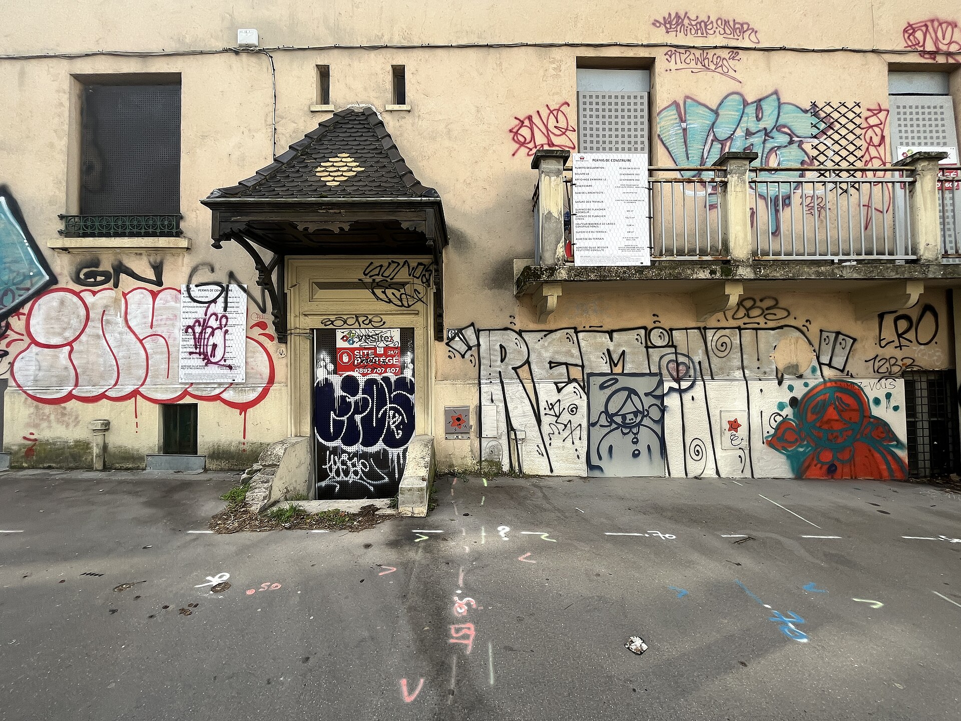 Façade d'un immeuble ancien à Lyon avec panneaux de permis de construire affichés